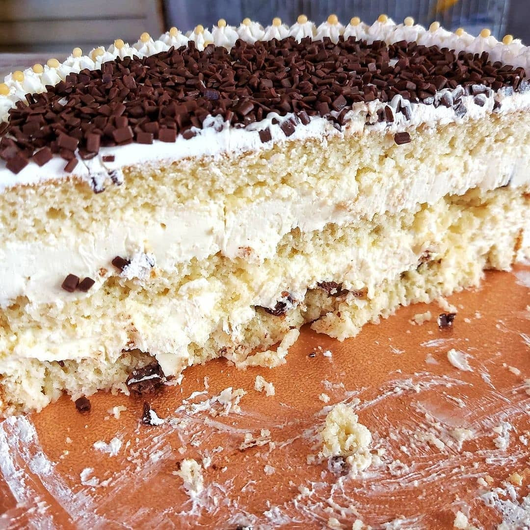 Bolo com recheio de Mousse de Ninho e Bombons, cobertura chantilly e chocolate picado