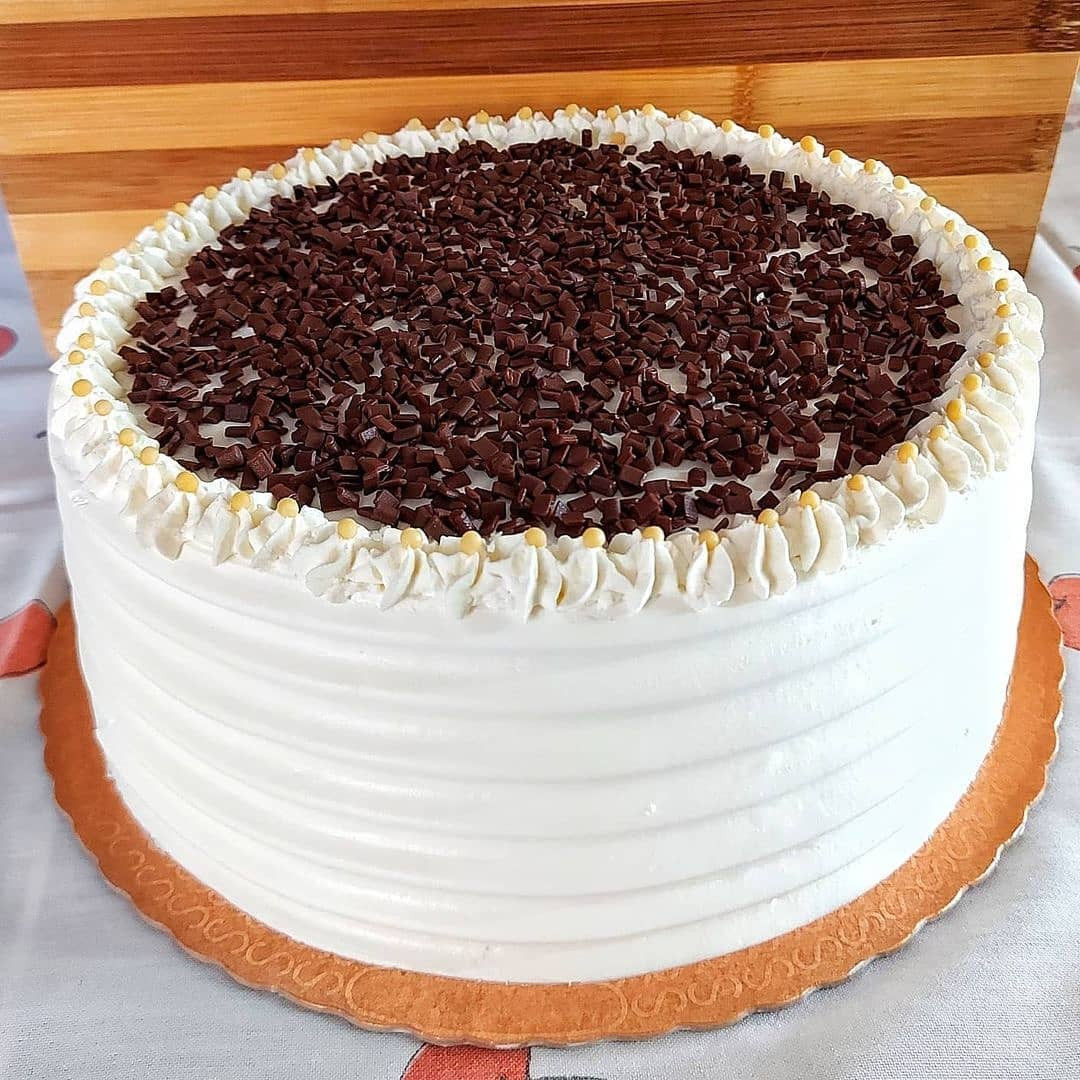 Bolo com recheio de Mousse de Ninho e Bombons, cobertura chantilly e chocolate picado