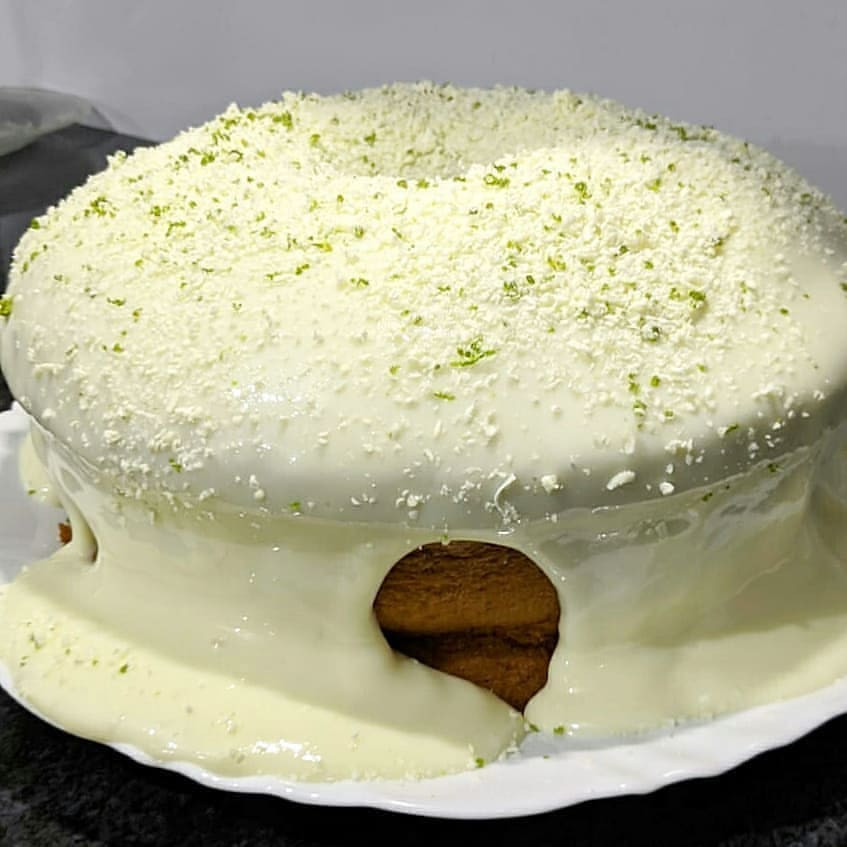 Bolo mousse de limão com cobertura branca e raspas verdes