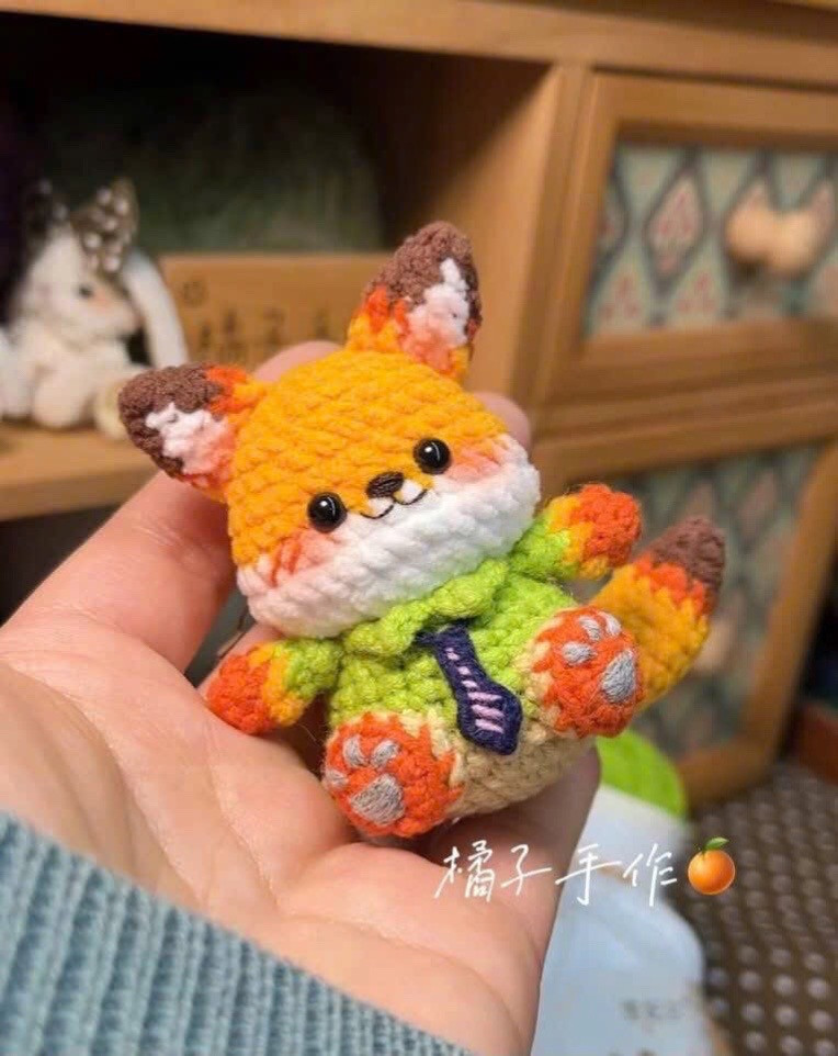 Chart móc len Cáo Nick màu cam mặc áo xanh lá