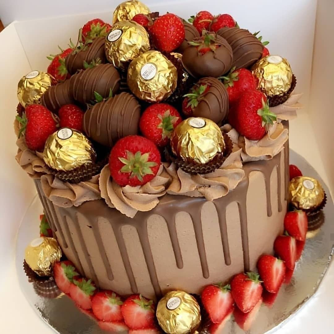 Chocolate drip cake topped with fresh strawberries and Ferrero Rocher chocolates