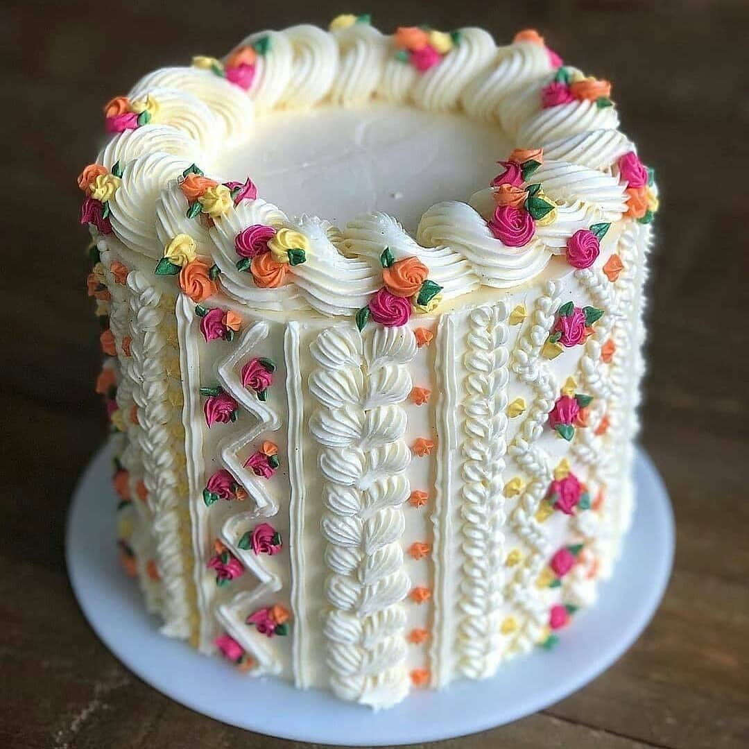Delicious buttercream cake decorated with colorful flowers and intricate piping patterns