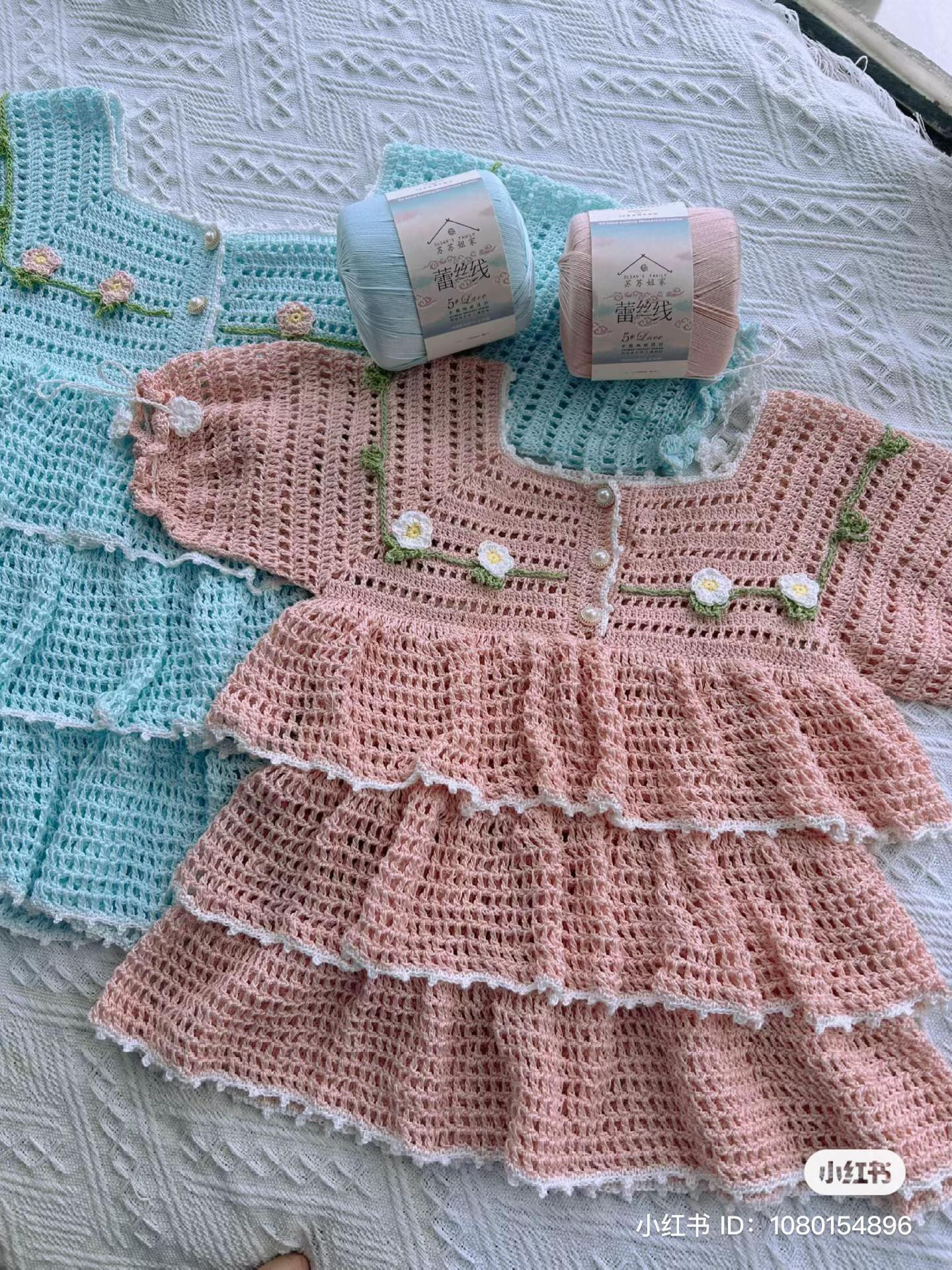 Hand-drawn crochet chart pattern for a baby dress with tiered ruffles and floral embroidery details