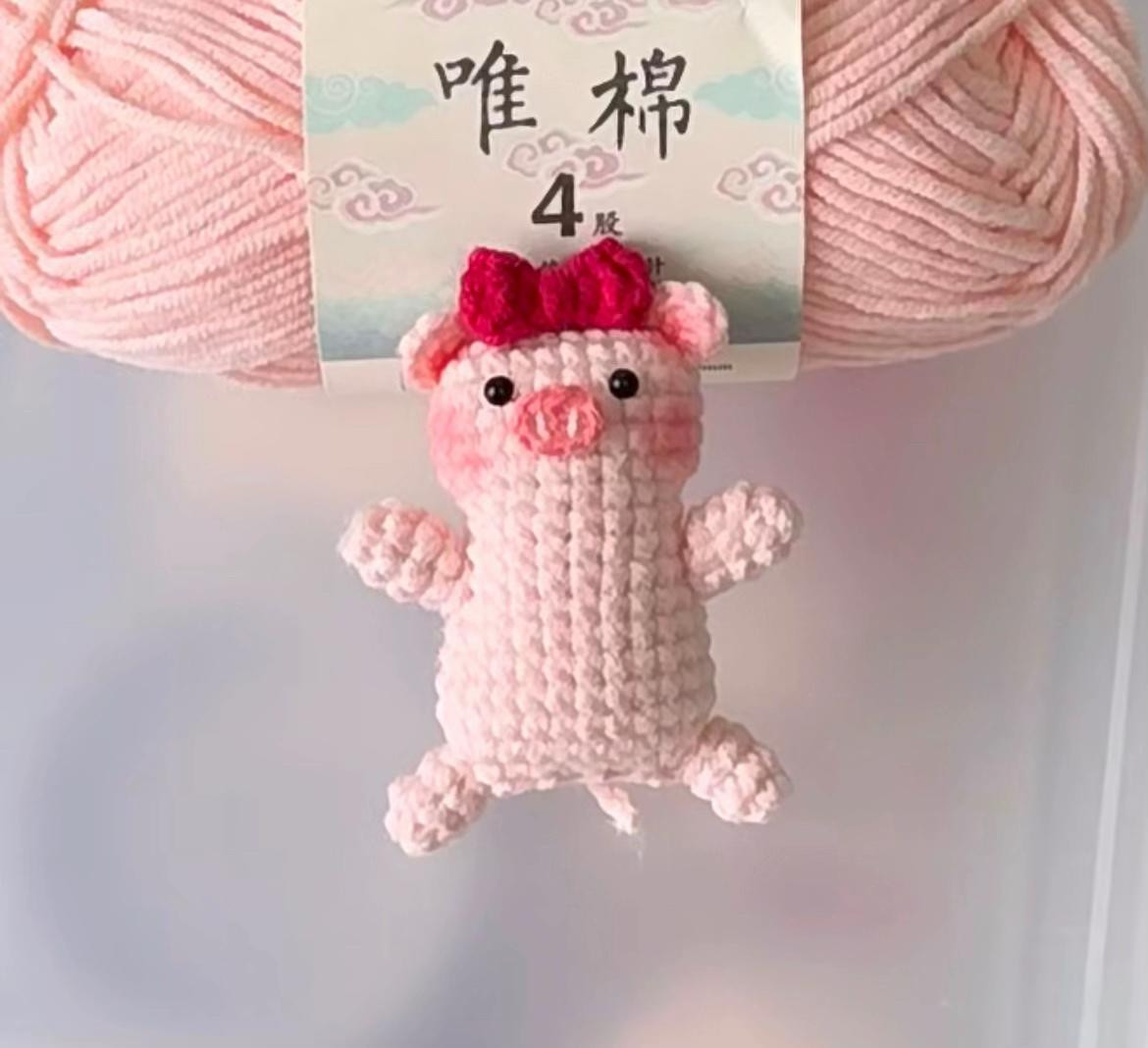 Handwritten crochet pattern chart for a flat pink pig amigurumi with red bow