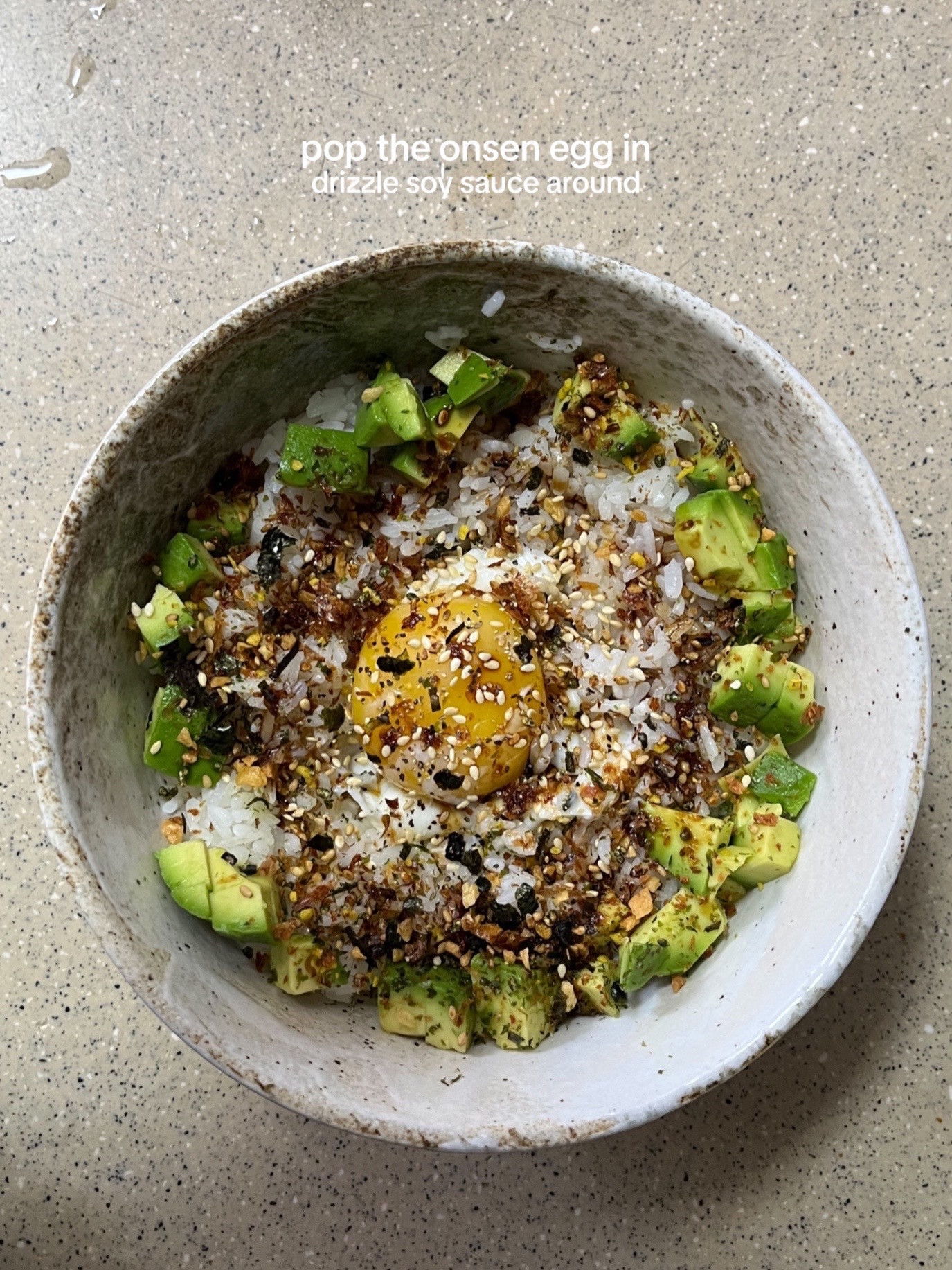 How to make a simple and nourishing onsen egg bowl with rice, avocado, furikake, garlic chips, and sesame