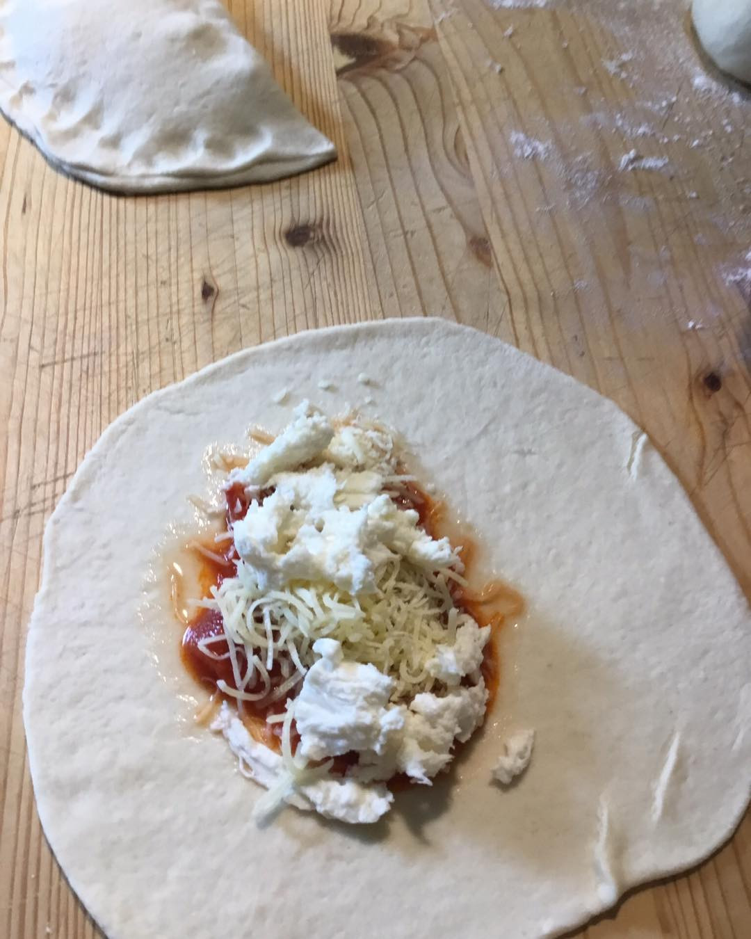 Mezze lune farcite cotte in padella con pomodoro e basilico