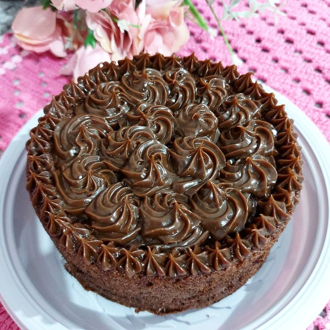 Mini bolinho de chocolate com cobertura cremosa e decoração em rosetas