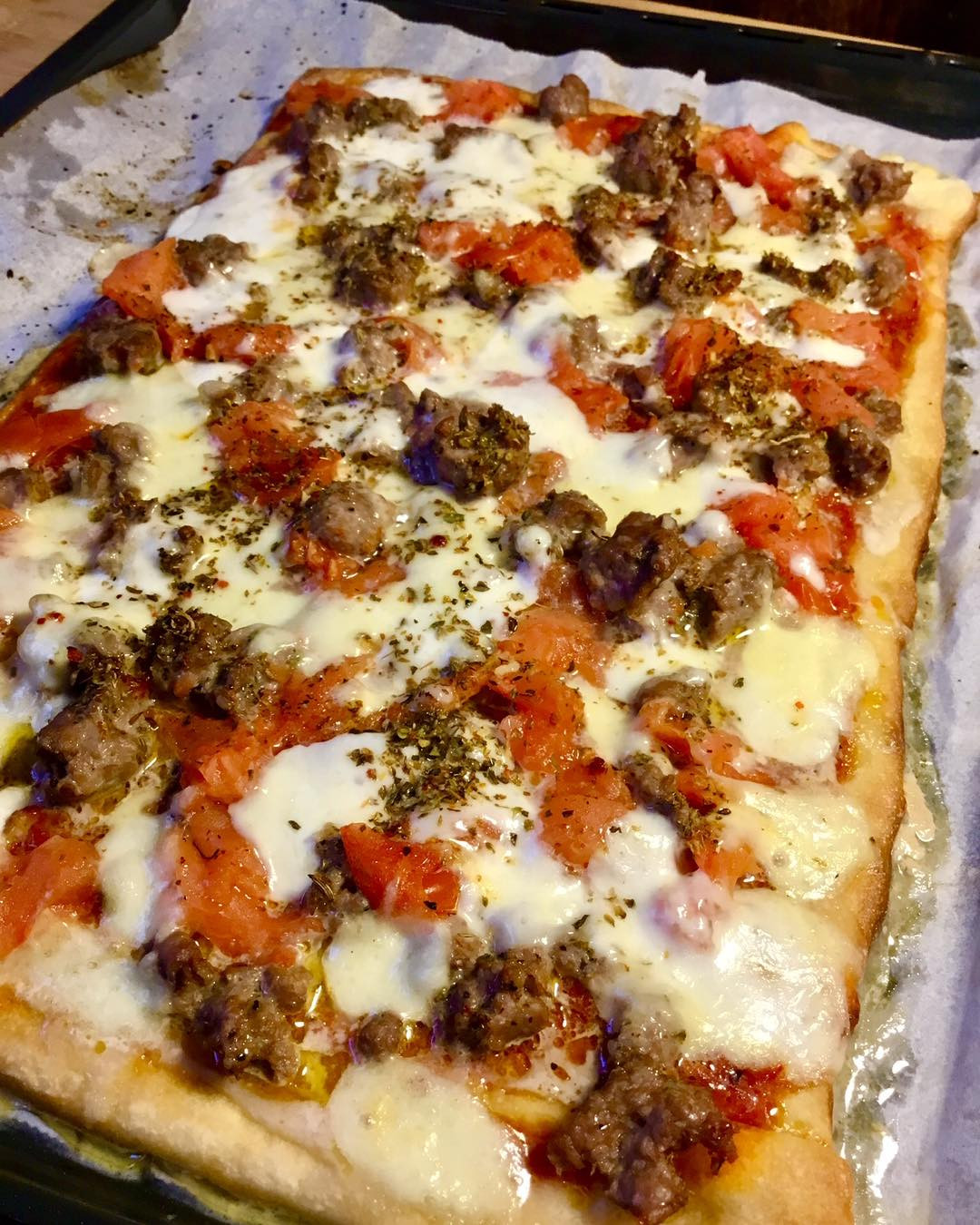 Pizza fatta in casa con salsiccia fresca e pomodori, ricetta semplice e veloce