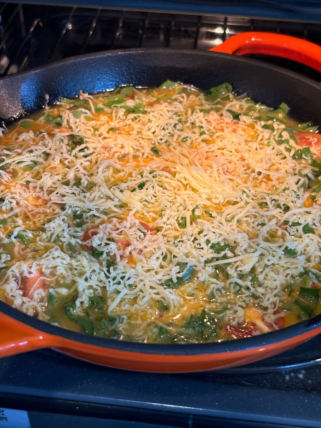 Quick, easy, healthy breakfast frittata with cherry tomatoes and greens cooked in Le Creuset cast iron skillet