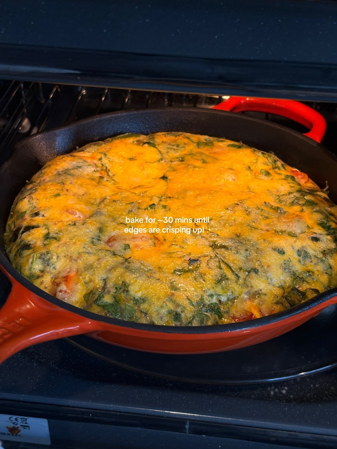 Quick, easy, healthy breakfast frittata with cherry tomatoes and greens cooked in Le Creuset cast iron skillet