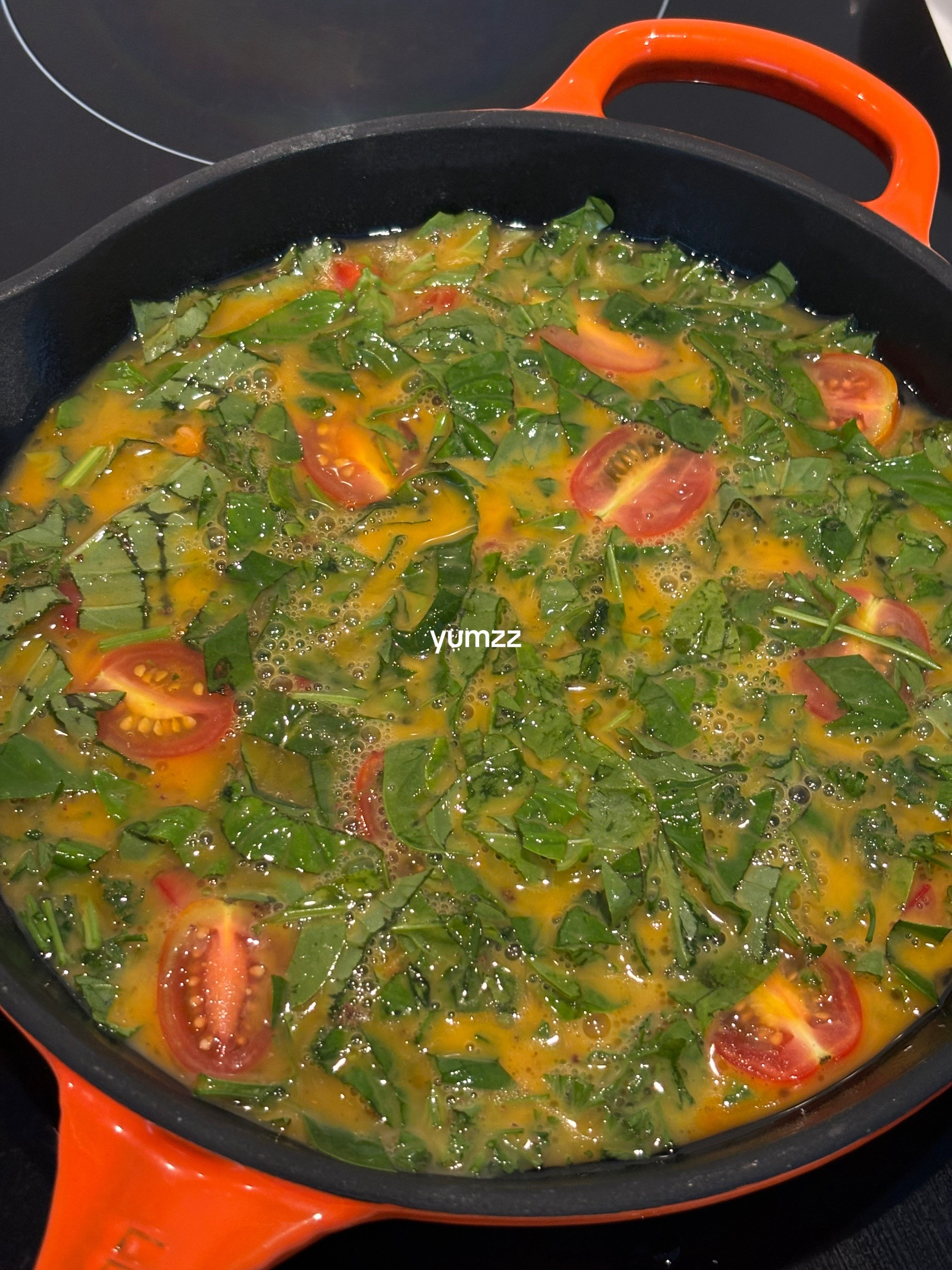 Quick, easy, healthy breakfast frittata with cherry tomatoes and greens cooked in Le Creuset cast iron skillet