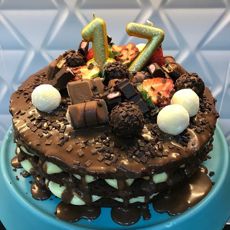 Receita de Bolo de Chocolate com Iogurte decorado com brigadeiros e morangos