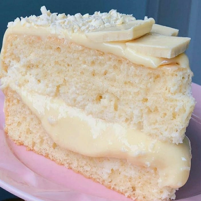 Receita de Bolo Leite Ninho com cobertura de chocolate branco e coco ralado