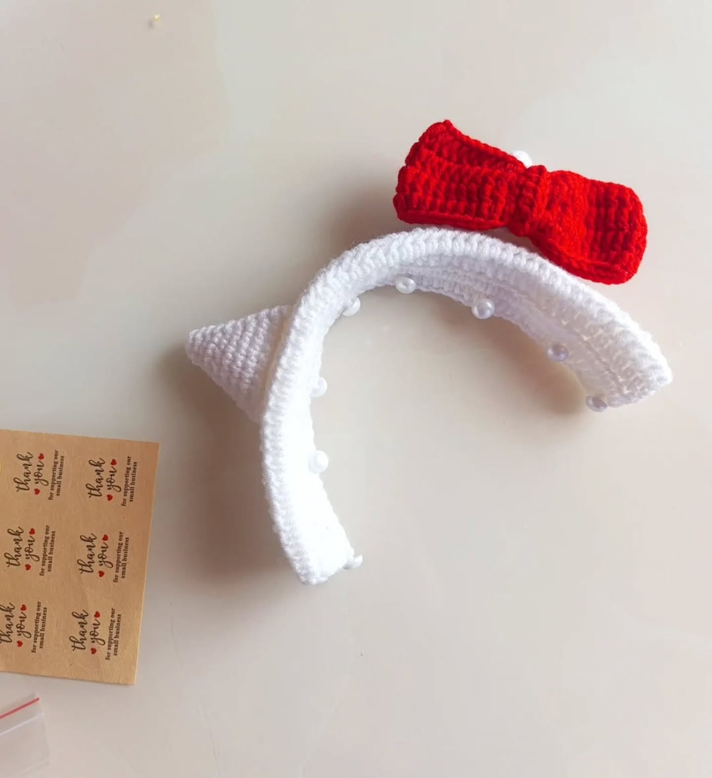 Free Crochet Pattern: Hello Kitty Inspired Headband Cover with Cat Ears and Red Bow