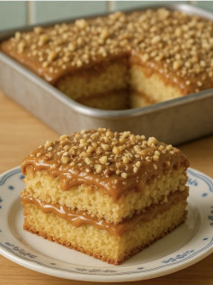 Bolo de massa fofinha recheado e coberto com doce de leite cremoso e nozes picadas