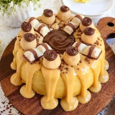 Bolo Kinder com Doce de Leite: Cake decorated with caramel sauce, chocolate cream, and Kinder candies