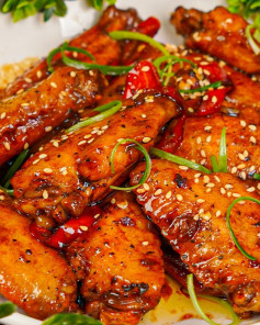 Cánh gà kho Coca sốt nâu bóng, giòn da, mềm ngọt, rắc vừng và hành lá