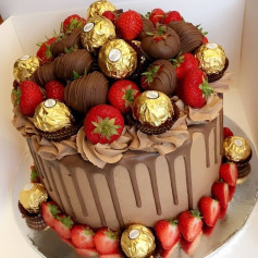 Chocolate drip cake topped with fresh strawberries and Ferrero Rocher chocolates