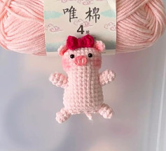 Handwritten crochet pattern chart for a flat pink pig amigurumi with red bow