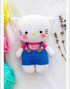 Patrón de crochet amigurumi Hello Kitty con overol azul y camiseta rosa, instrucciones paso a paso