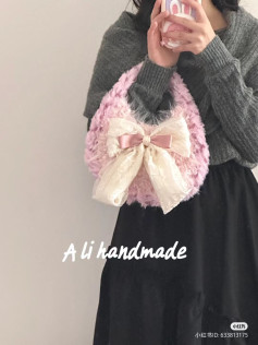 Pink fluffy crocheted handbag with large cream bow pattern