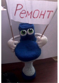 Схема амигуруми «Унитаз» — забавная игрушка с глазами и руками, держащая флажок «Ремонт», вязаная крючком из шерсти и акрила