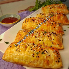 Chicken Tikka Puff: Golden puff pastry filled with spicy chicken tikka, cream, and mozzarella cheese, topped with sesame seeds